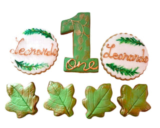 Biscotti decorati a forma di foglie d’autunno e numero 1, realizzati artigianalmente in pasta frolla e pasta di zucchero, ideali per compleanni e feste a tema autunnale.